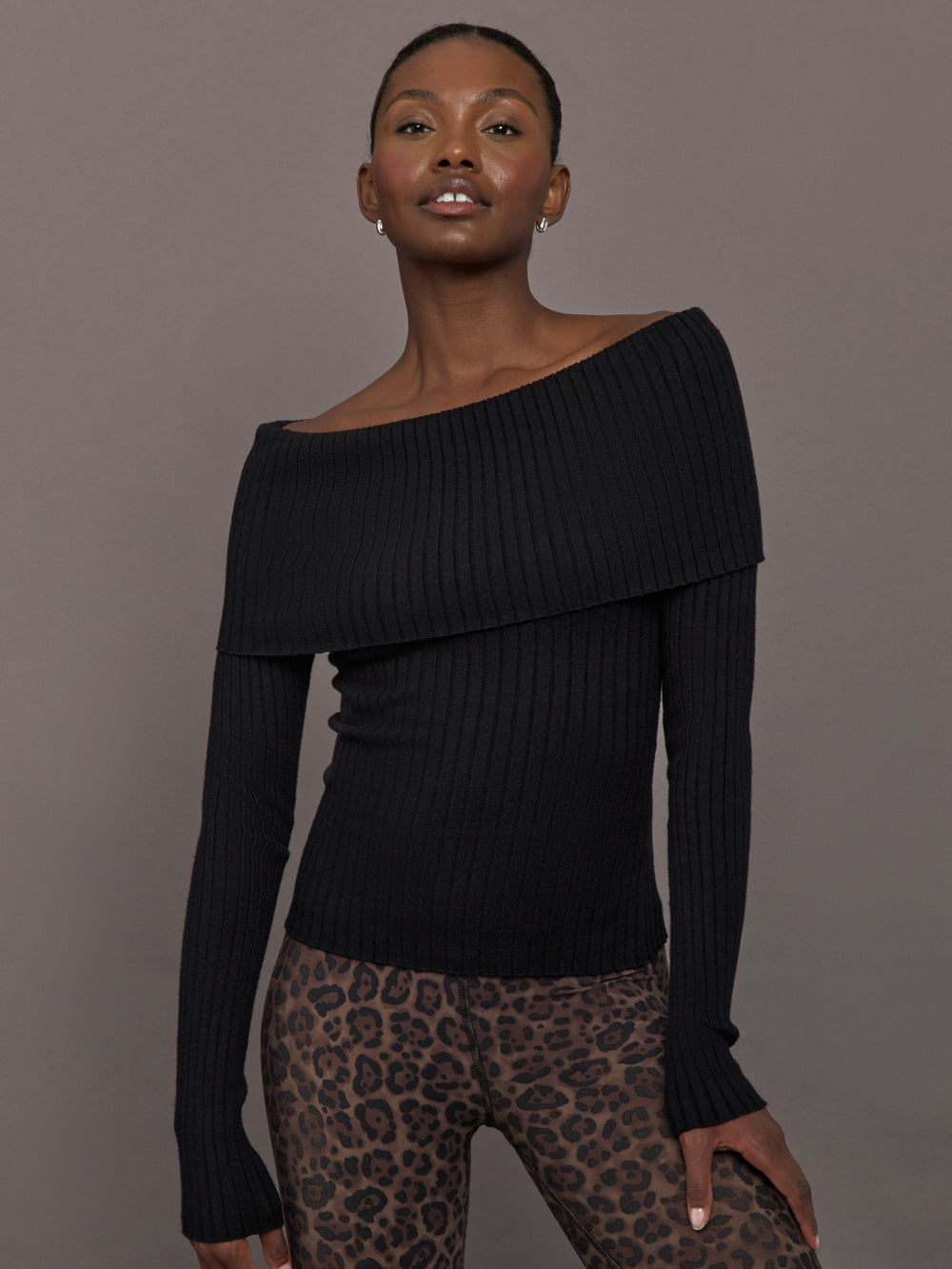 Model wearing a black off-shoulder sweater