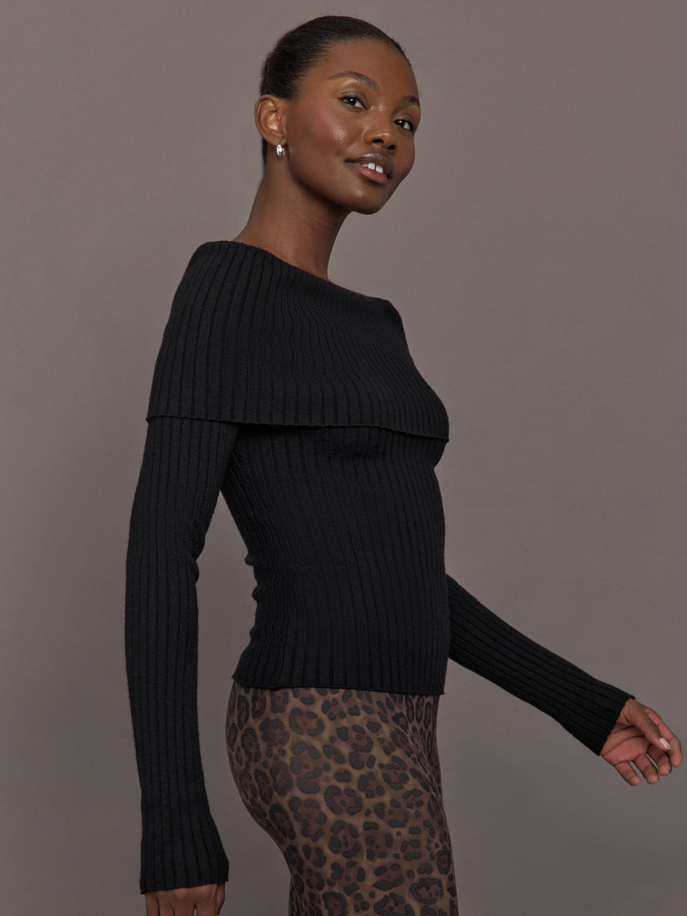 Model wearing a black off-shoulder sweater