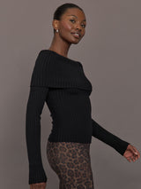 Model wearing a black off-shoulder sweater