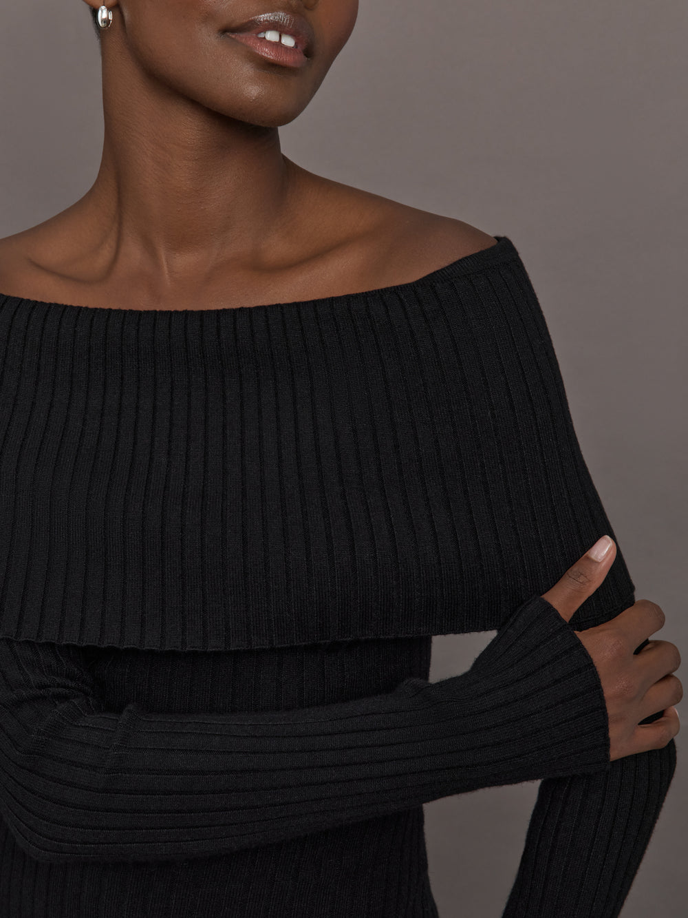 Model wearing a black off-shoulder sweater