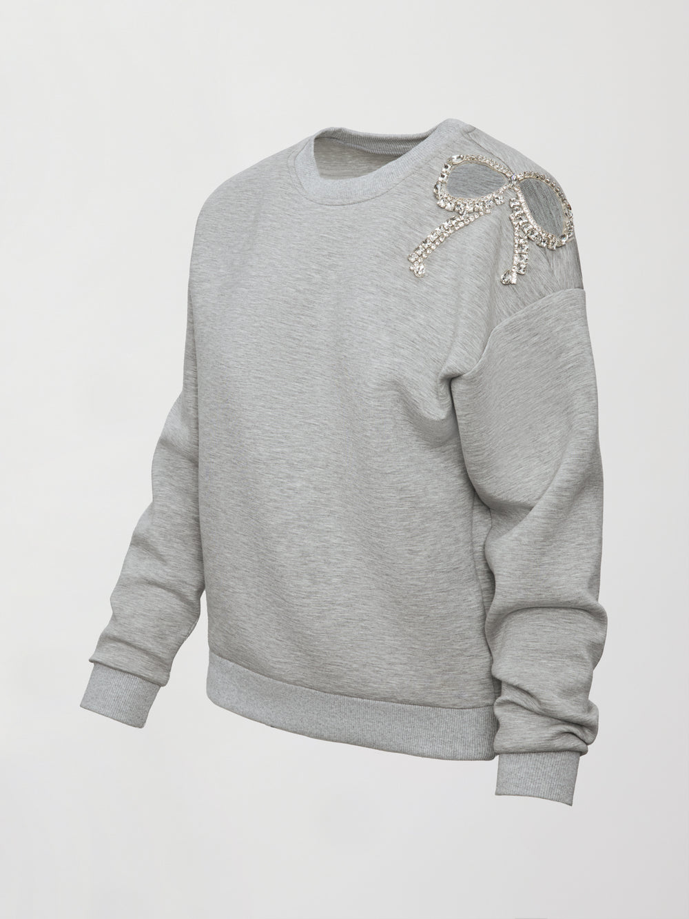 Product shot of grey bow embellished sweatshirt with jeweled bow accent on shoulder, front angled view.