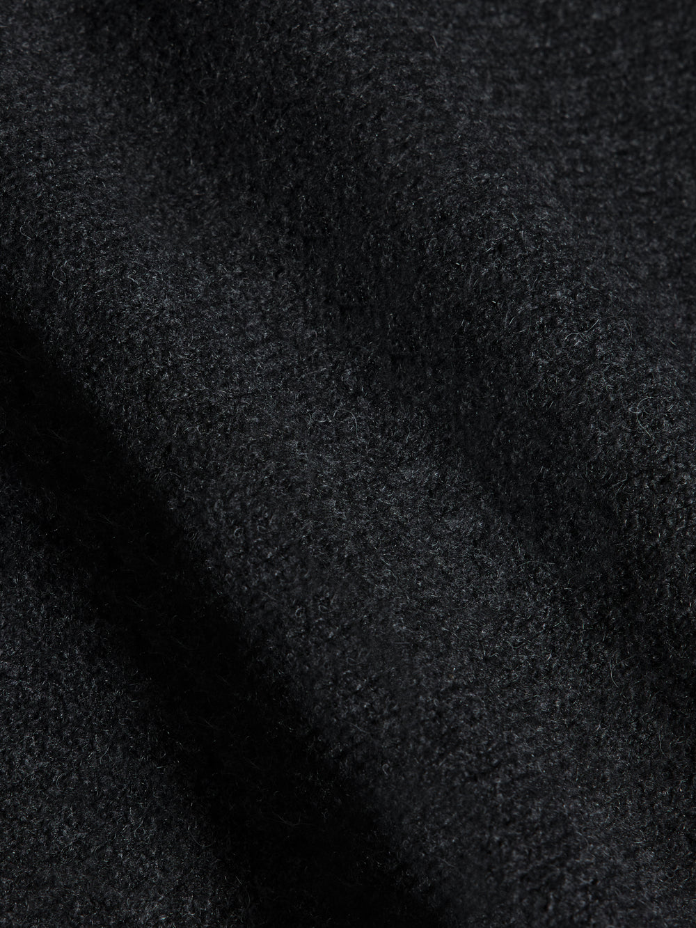 Fabric detail of charcoal knit material from Tassel Shawl Collar Sweater, showing soft textured weave.