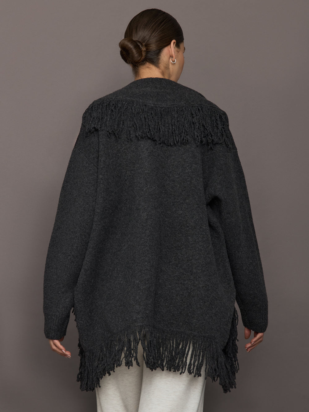 Back view of Tassel Shawl Collar Sweater in charcoal with fringe detail along yoke and hem.