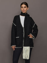 Model wearing Sweater with Scarf in black with cream whipstitch trim and fringe scarf, front view.