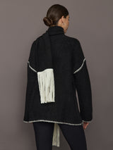 Back view of Sweater with Scarf in black showing cream whipstitch trim and scarf draped with fringe.