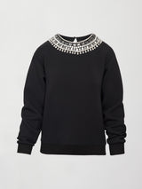 Flat lay of black jewel embellished sweatshirt with crystal neckline detail on white background.