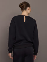 Back view of black jewel embellished sweatshirt with keyhole closure at neck.