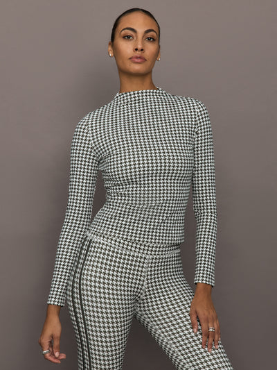 Model wearing long sleeve houndstooth mock neck top, front view close-up.