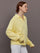 Model is wearing French Terry Johnny Collar Sweatshirt in Banana, side profile view.