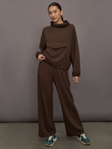 Model is wearing Scuba Funnel Neck Pullover in Carafe, full body front view styled with matching pants.