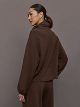 Model is wearing Scuba Funnel Neck Pullover in Carafe, back view.