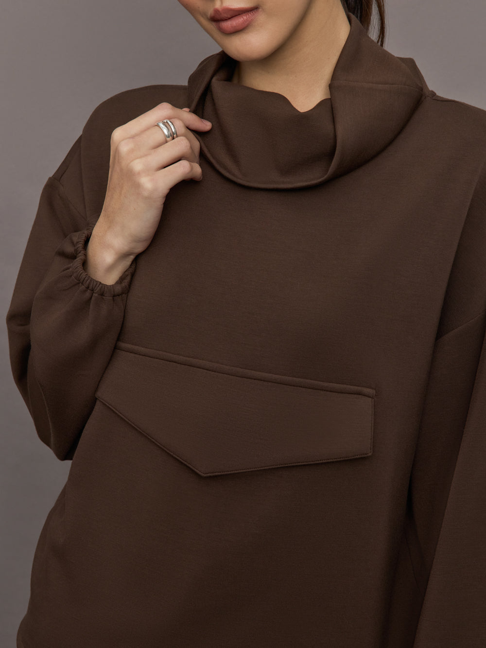 Model is wearing Scuba Funnel Neck Pullover in Carafe, close up of funnel neckline detail.