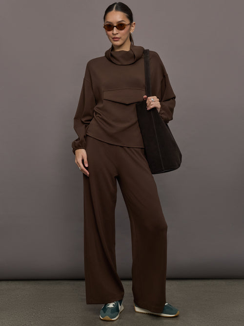 Model is wearing Scuba Mid Rise Pull On Pant in Carafe, full body styled with tote and sunglasses.