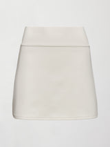 Model wears white tennis skirt with a smooth, fitted waistband and subtle flare.

