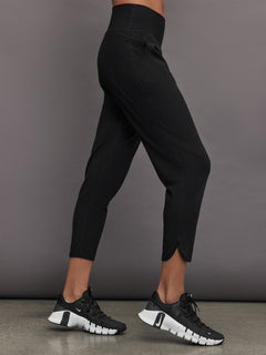 Model wears black high-rise joggers with a slim, relaxed fit, slightly cropped legs and tulip hems.