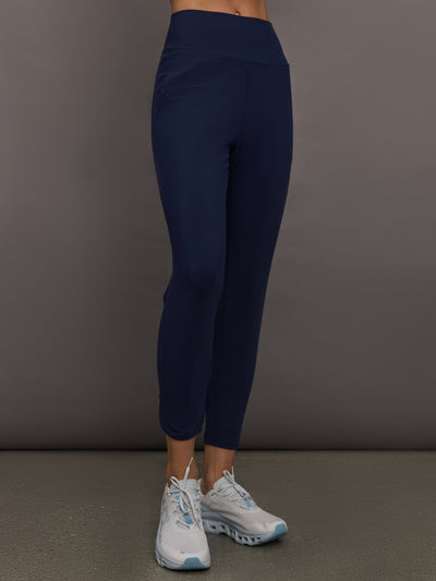 Model wears navy high-rise joggers with a slim, relaxed fit and a slightly cropped tulip-shaped hem and a wide waistband.

