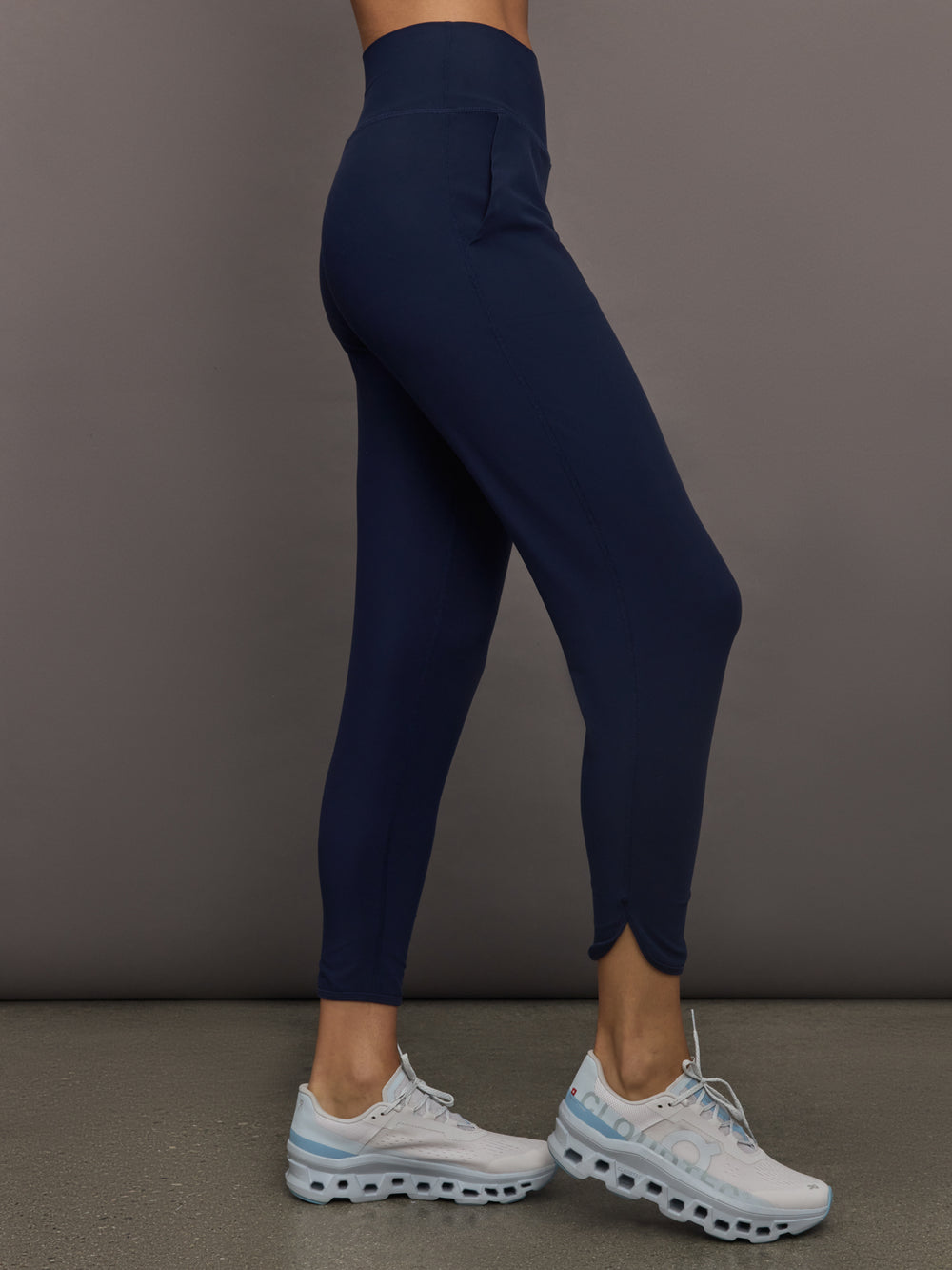 Model wears navy high-rise joggers with a slim, relaxed fit and a slightly cropped tulip-shaped hem and a wide waistband.
