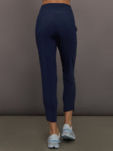 Model wears navy high-rise joggers with a slim, relaxed fit and a slightly cropped tulip-shaped hem and a wide waistband.
