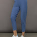 Model wears a pair of lightweight blue joggers with a wide waistband and pockets. 
