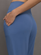 Model wears a pair of lightweight blue joggers with a wide waistband and pockets. 