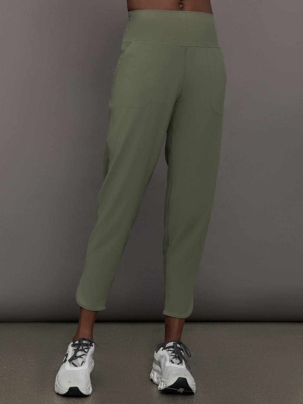 Model wears a pair of army green colored joggers with a thick waistband perfect for everyday activities. 