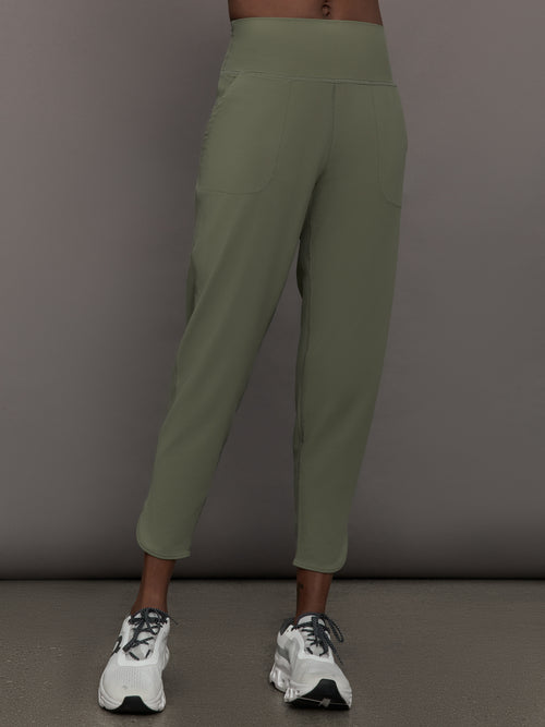 Model wears a pair of army green colored joggers with a thick waistband perfect for everyday activities. 