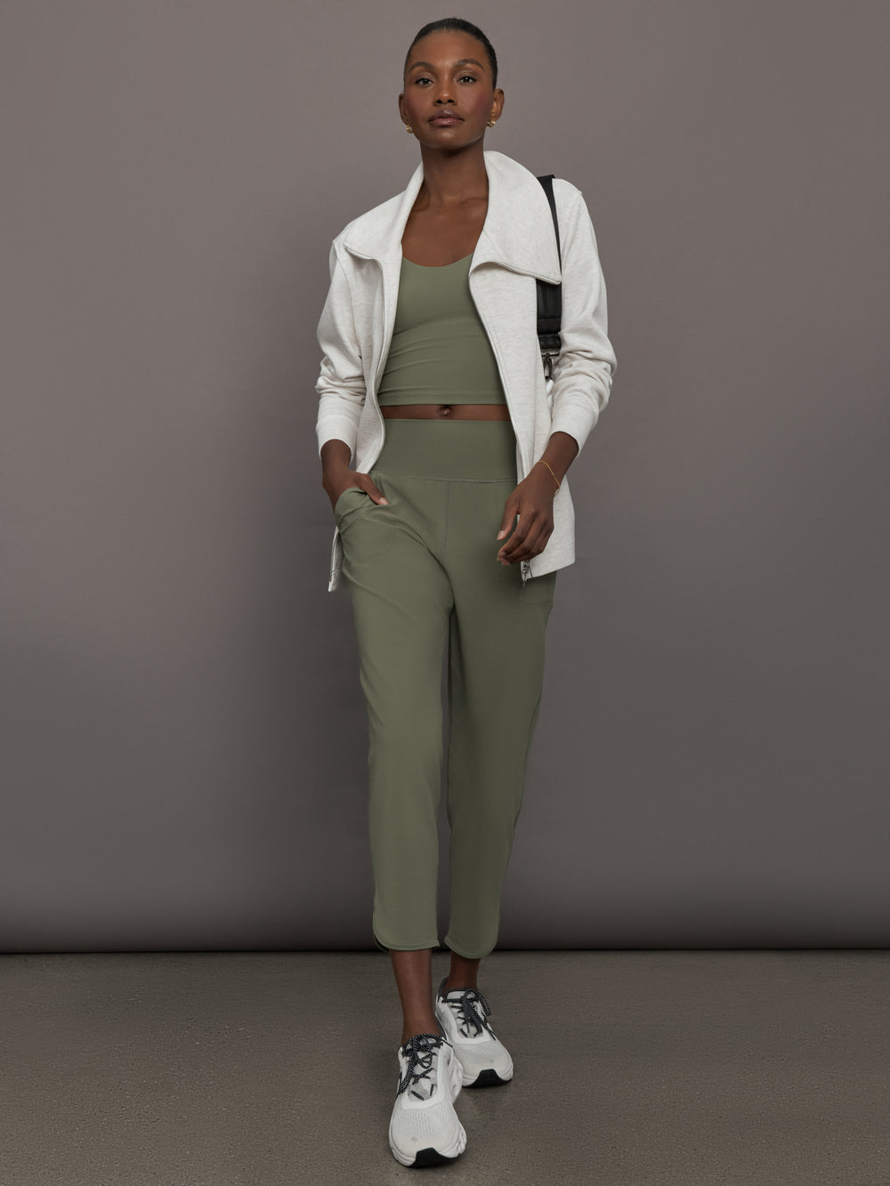 Model wears a pair of army green colored joggers with a thick waistband perfect for everyday activities. 