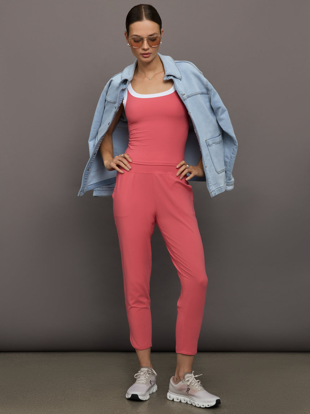 Model wears a buttery soft, high waisted, salmon pink colored pair of jogger sweatpants. 