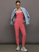 Model wears a buttery soft, high waisted, salmon pink colored pair of jogger sweatpants. 