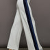 Model wearing ivory wide leg track pants with blue and black stripe on the side.