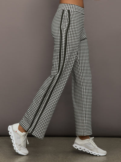 Side view of houndstooth track pants with contrast side stripes and high-rise waistband.
