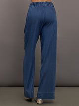 Model wears medium wash pants with an elastic waist and relaxed, wide-leg fit.