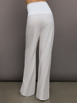 Model wears high-waisted, white wide-leg linen pants.