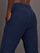 Model wears mid rise navy joggers with thick ankle band. 