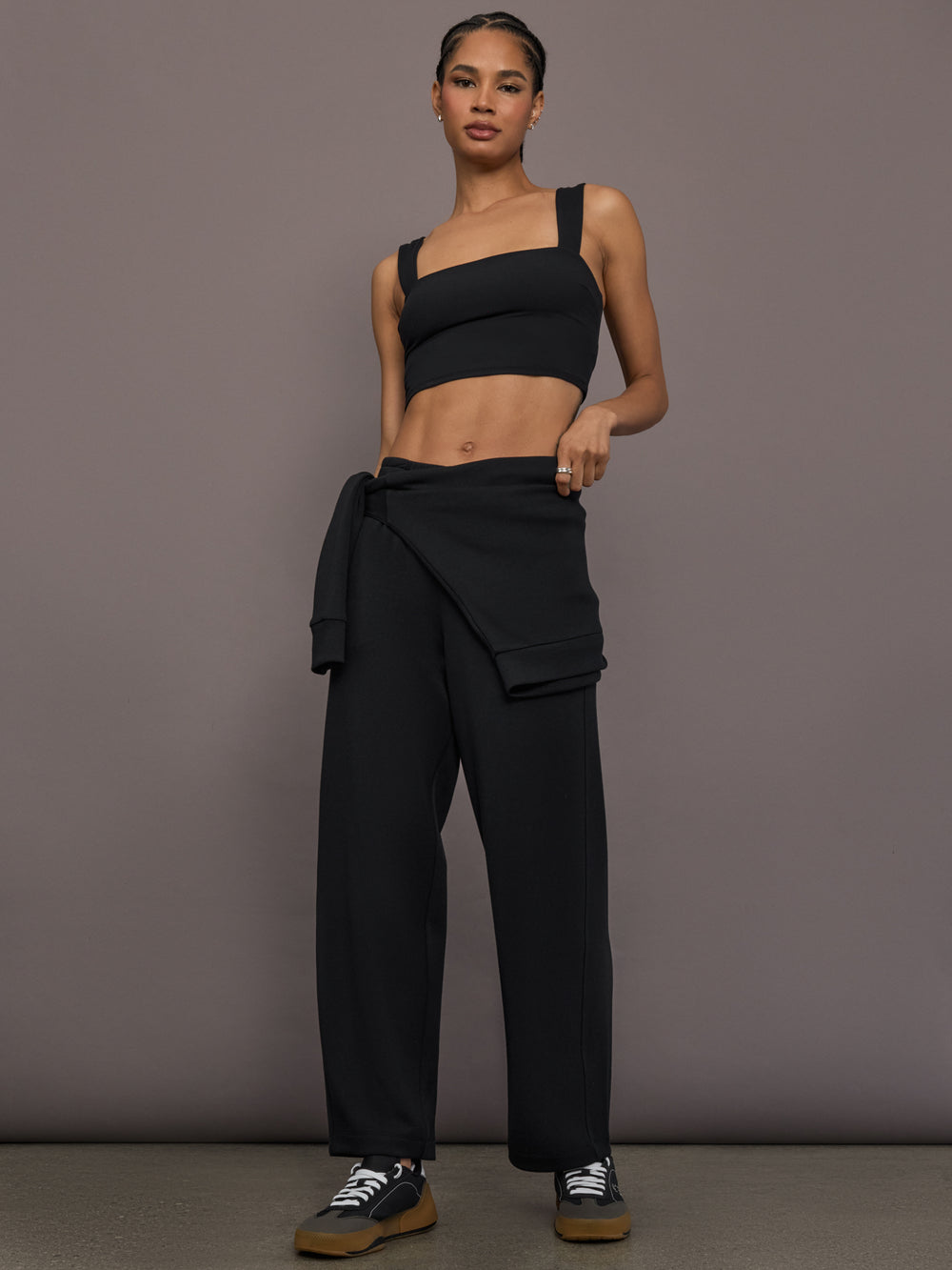 Model is wearing Interlock barrel leg pant in black, full body view.