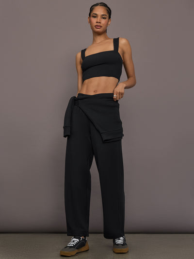 Model is wearing Interlock barrel leg pant in black, full body view.