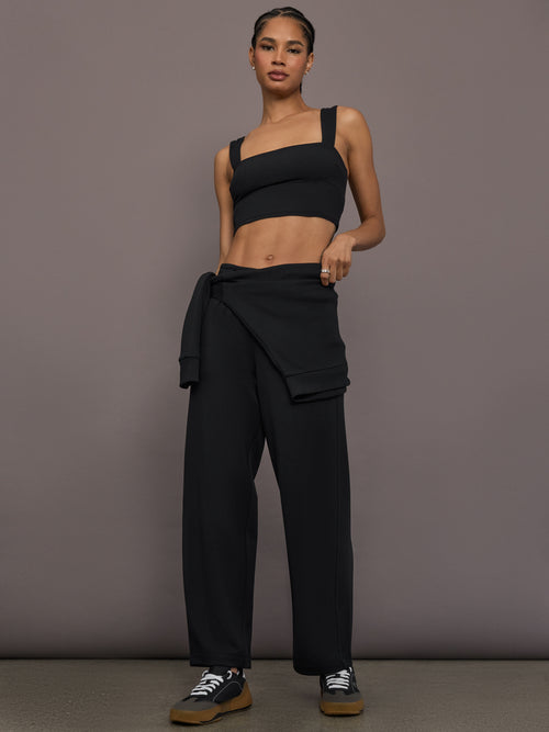 Model is wearing Interlock barrel leg pant in black, full body view.