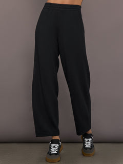 Model is wearing Interlock barrel leg pant in black, front view.