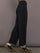 Model is wearing Interlock barrel leg pant in black, side view.