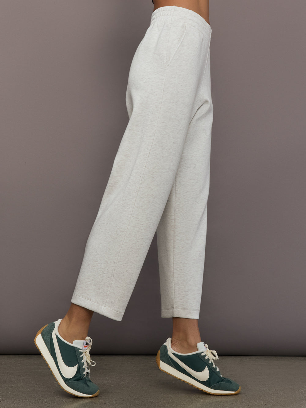 Model is wearing Interlock barrel leg pant in Moonbeam Heather, side profile view.
