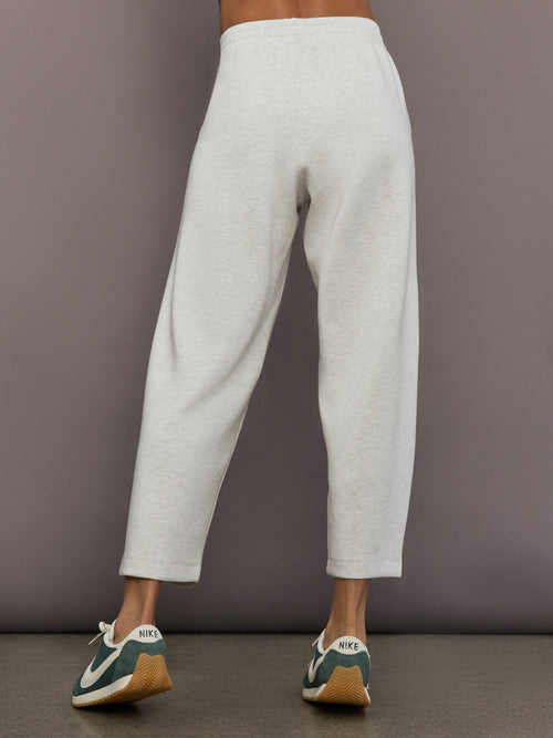 Model is wearing Interlock barrel leg pant in Moonbeam Heather, back view.