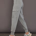 Model is wearing a heather grey Ultrasoft Cargo Jogger with flap pocket detail and tapered leg, side view.