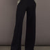 Model wearing black wide-leg embellished pants with jeweled pocket trim, front view.