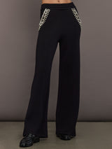 Model wearing black wide-leg embellished pants with jeweled pocket trim, front view.