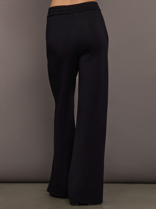 Back view of black wide-leg pants with relaxed fit and clean hem.