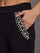 Close-up of jeweled embellishment on black wide-leg pants pocket.