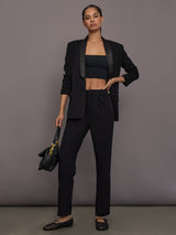 Model is wearing the Tuxedo Blazer in black, full body front view styled with matching pants.
