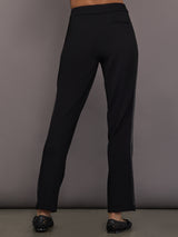 Model is wearing the scuba tuxedo pant in black, back view.