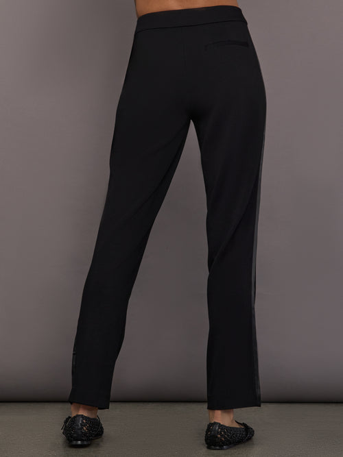 Model is wearing the scuba tuxedo pant in black, back view.