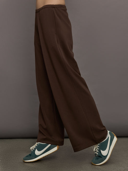 Model is wearing Scuba Mid Rise Pull On Pant in Carafe, side view.